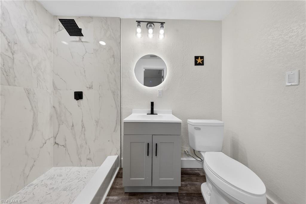 Shower with large format marble-look tile surround and black matte fixtures