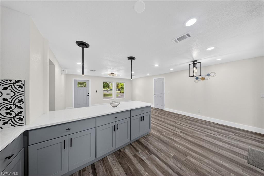 Kitchen island with grey cabinetry and a white countertop