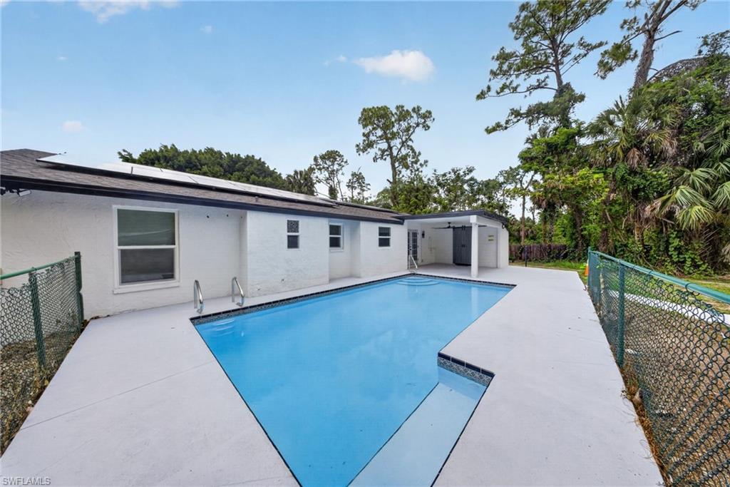 Rectangular swimming pool with integrated steps and metal handrails