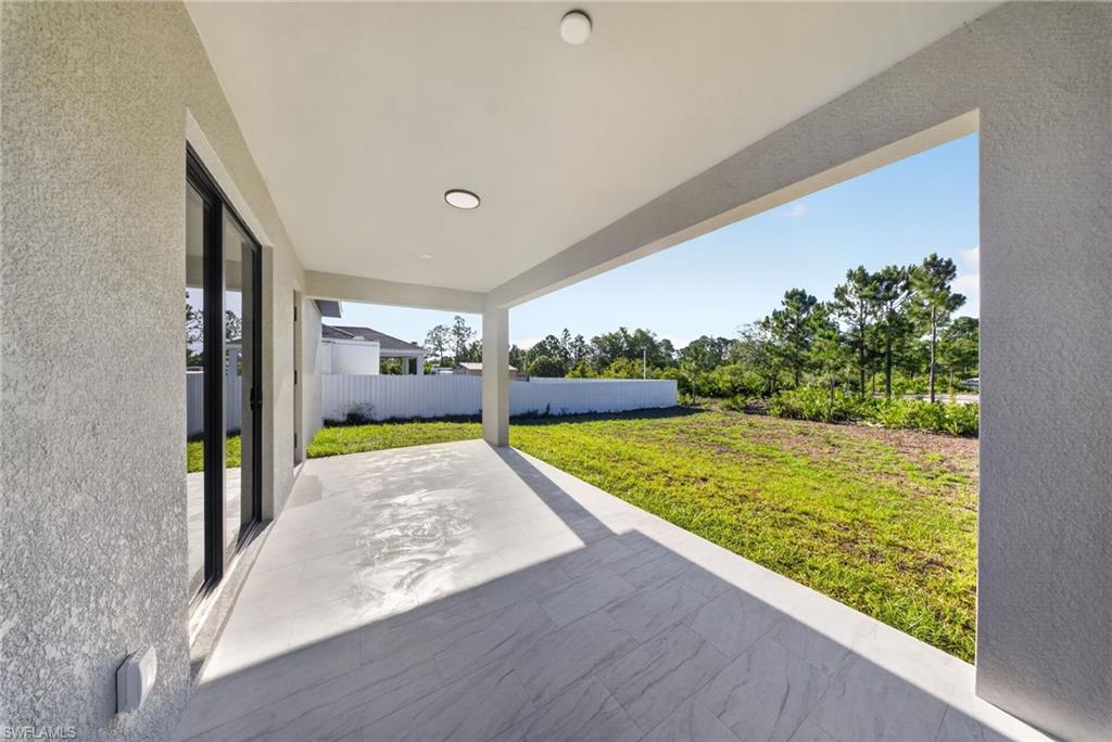 Expansive covered patio with large format tile flooring, recessed lighting, and a stucco exterior