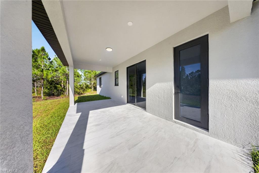 Expansive covered patio featuring a light-toned tile surface and recessed lighting
