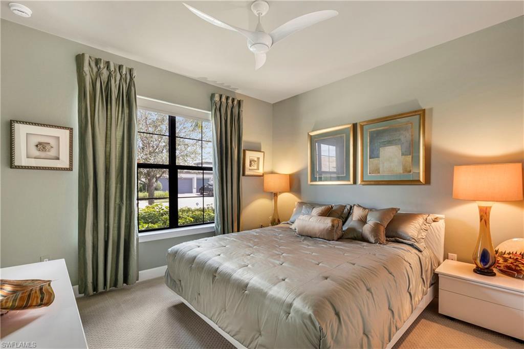 Bedroom featuring baseboards, a ceiling fan, and light colored carpet