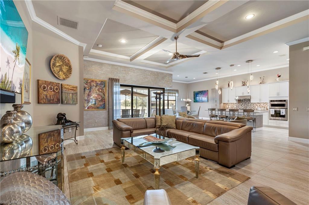 Living room featuring coffered ceiling, visible vents, and crown molding