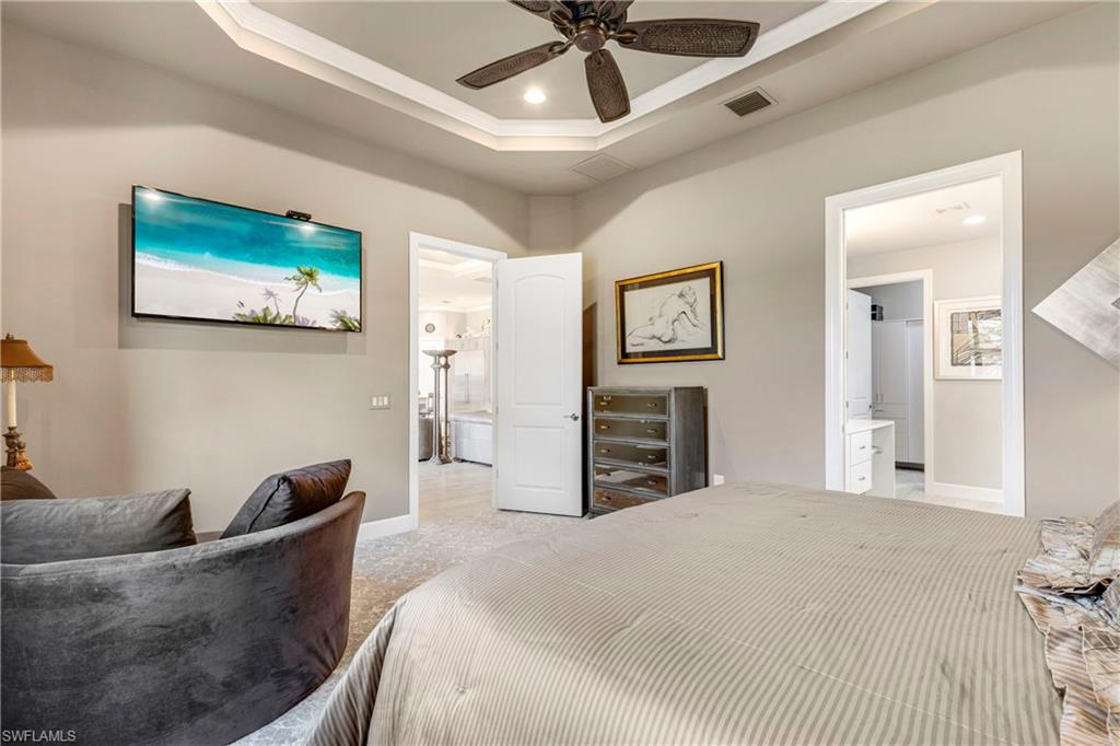 Bedroom with light carpet, baseboards, visible vents, a tray ceiling, and recessed lighting