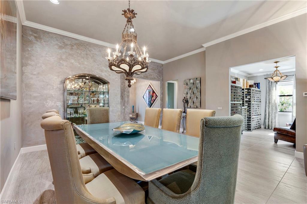 Dining room with crown molding, baseboards, and an inviting chandelier