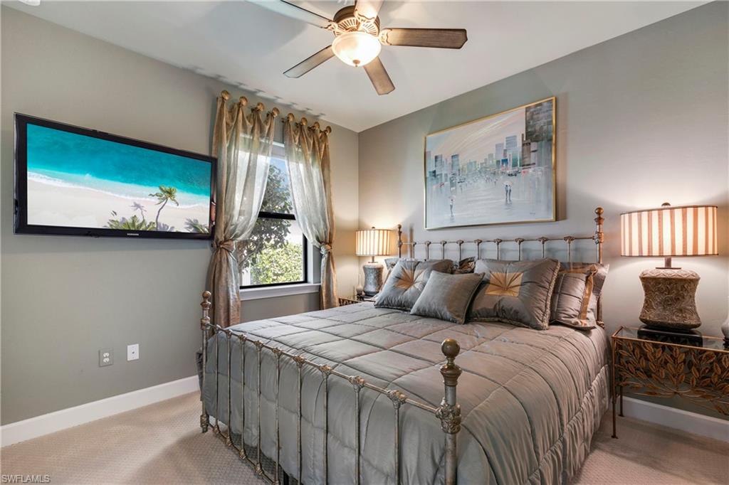 Bedroom featuring a ceiling fan, light carpet, and baseboards
