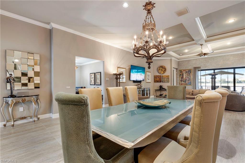 Dining room with baseboards, coffered ceiling, visible vents, and crown molding