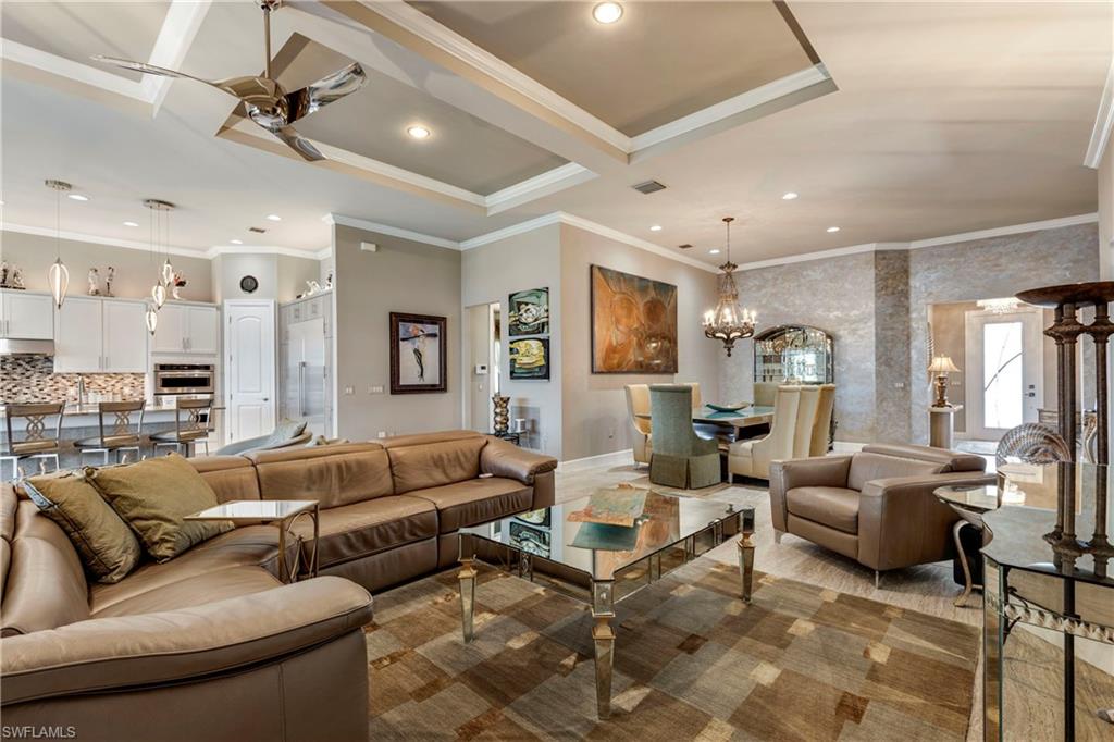 Living room featuring recessed lighting, visible vents, crown molding, and ceiling fan with notable chandelier