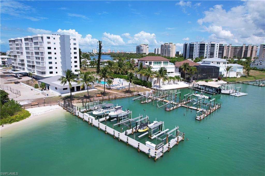 Waterfront property featuring a private beach, multiple boat slips, and a multi-story building