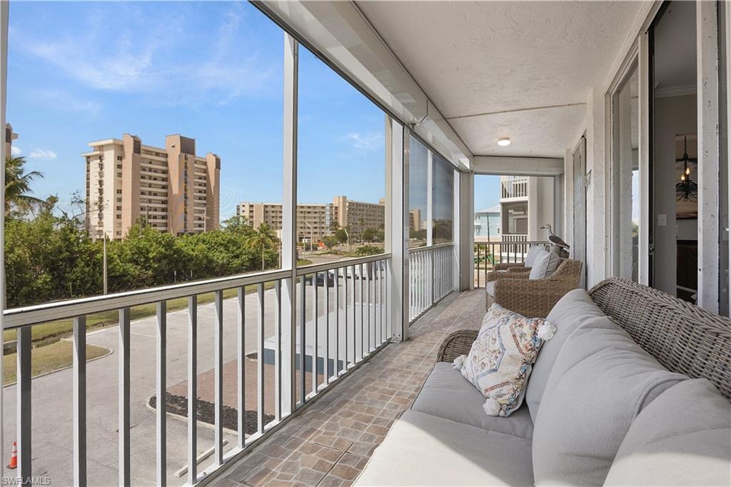 Screened balcony featuring textured ceiling, tiled flooring, and white railings