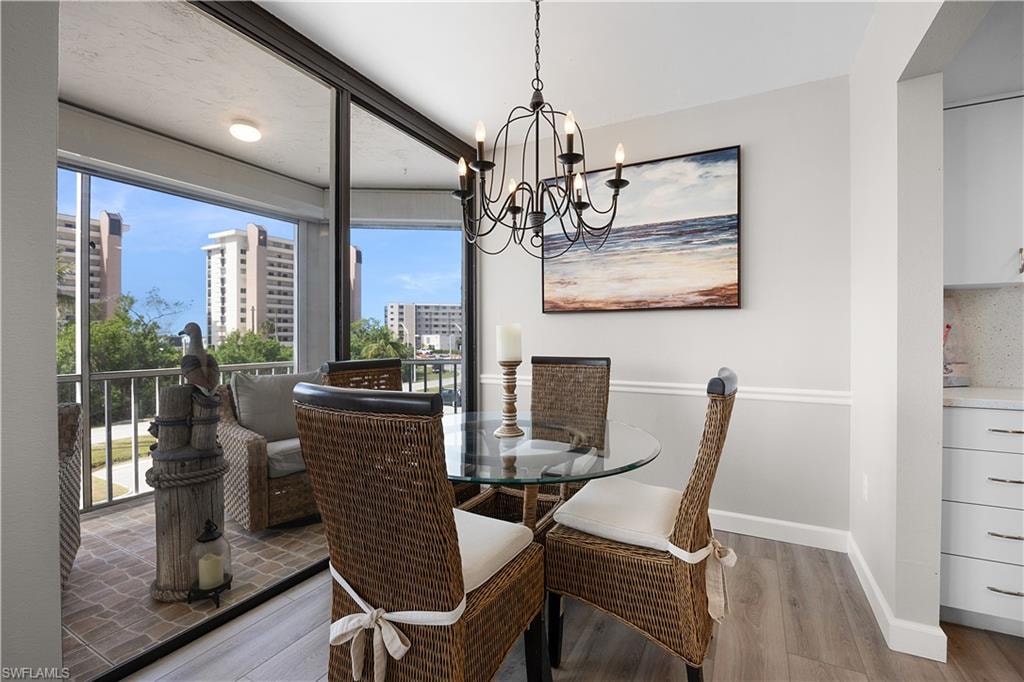 Dining area featuring wood-finish flooring and a contemporary chandelier