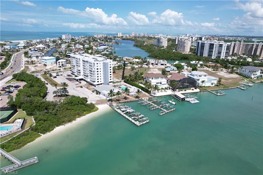 Waterfront property featuring a multi-story building, private docks, and a sandy shoreline