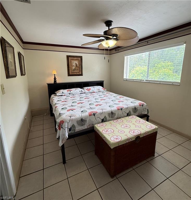 Room featuring tile flooring, a window with horizontal blinds, and a ceiling fan with integrated lighting