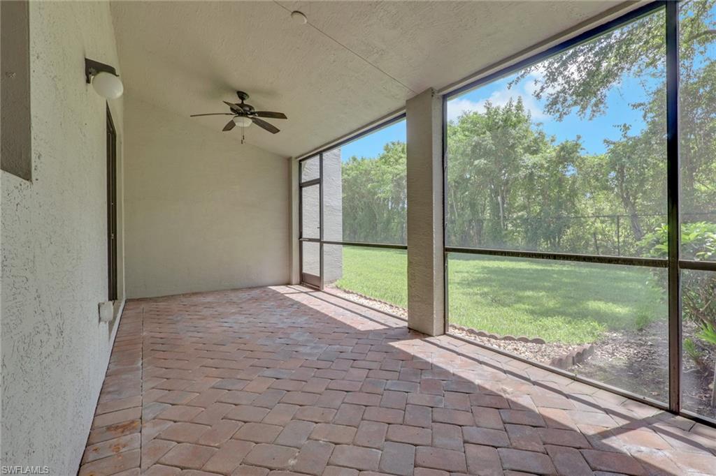 Screened lanai featuring brick paver flooring, a ceiling fan, and exterior wall lighting