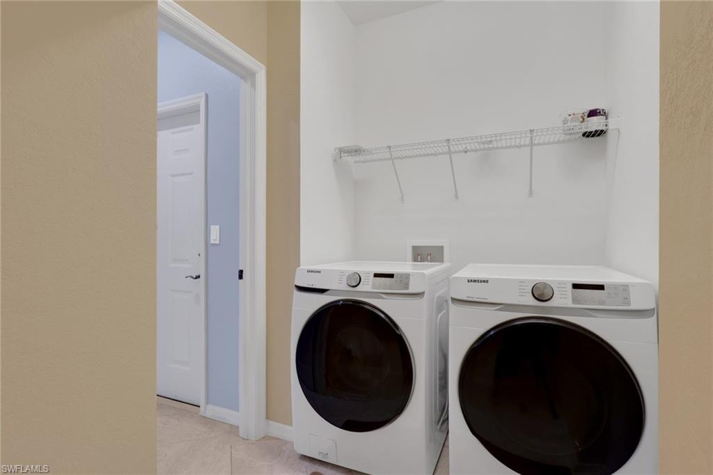 Dedicated laundry area featuring a wire storage shelf and light-colored tile flooring
