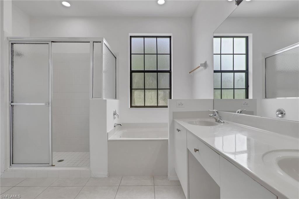 Spacious bathroom featuring a double vanity with integrated sinks and a large mirror