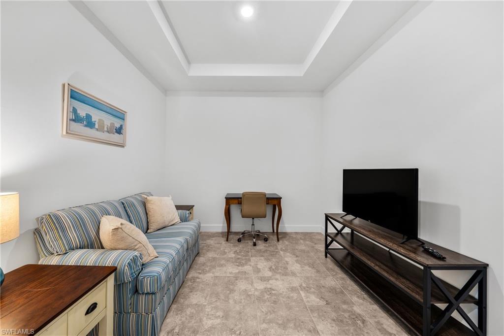 Tray ceiling accentuates this versatile room featuring recessed lighting, bright white walls, and durable tile flooring