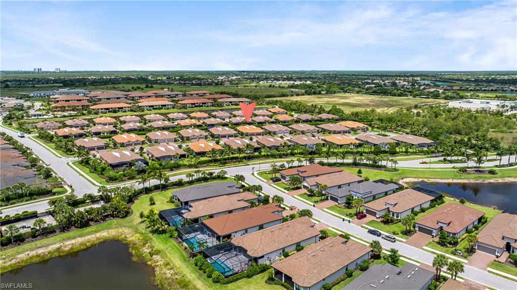 Expansive residential community featuring a variety of single-story homes with tile roofs, manicured lawns, and paved roads