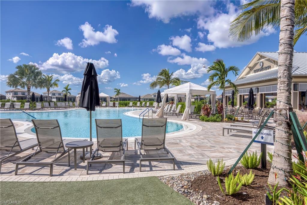 Expansive resort-style swimming pool @ main clubhouse featuring a curved perimeter, white coping, and surrounding lounge chairs