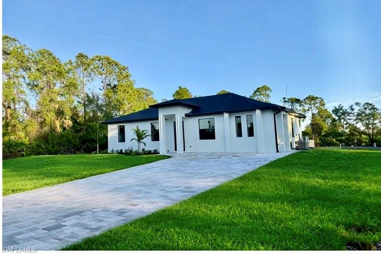 Contemporary single-story home featuring a dark shingle roof and a white stucco exterior
