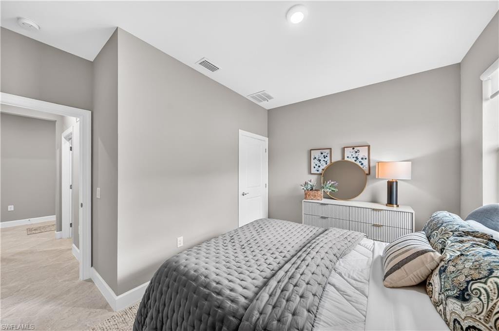 Bedroom featuring light neutral wall paint, white trim, recessed lighting, and a white interior door