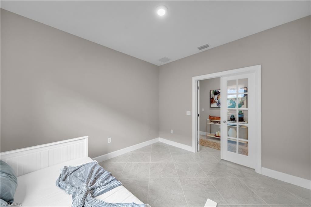 Room featuring neutral wall tones, white baseboards, and light-toned tile flooring