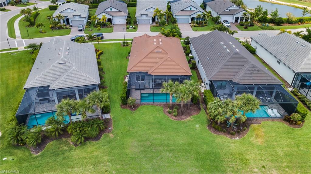 Aerial perspective showcasing multiple properties, each featuring a screened-in swimming pool, paved pool deck, and mature landscaping