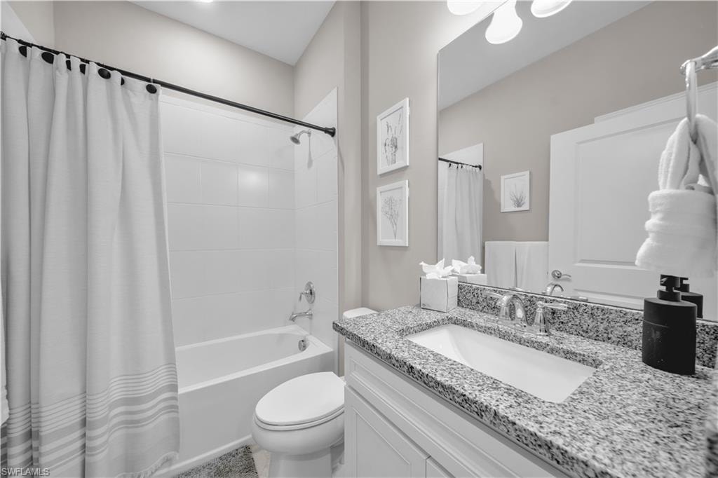 Bathroom featuring a white vanity with a granite countertop, undermount sink, and chrome fixtures