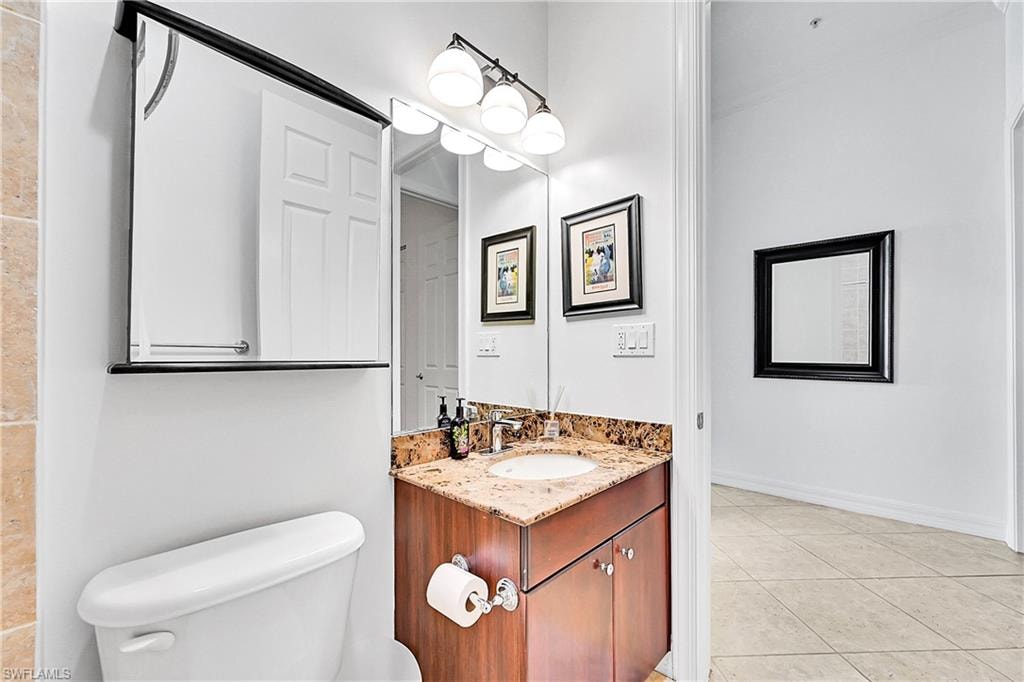 Bathroom with toilet, tile patterned floors, and vanity