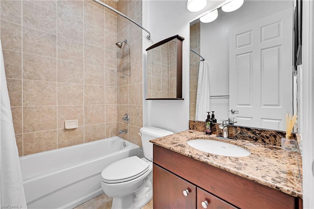 Full bath featuring shower / bath combination with curtain, toilet, and vanity