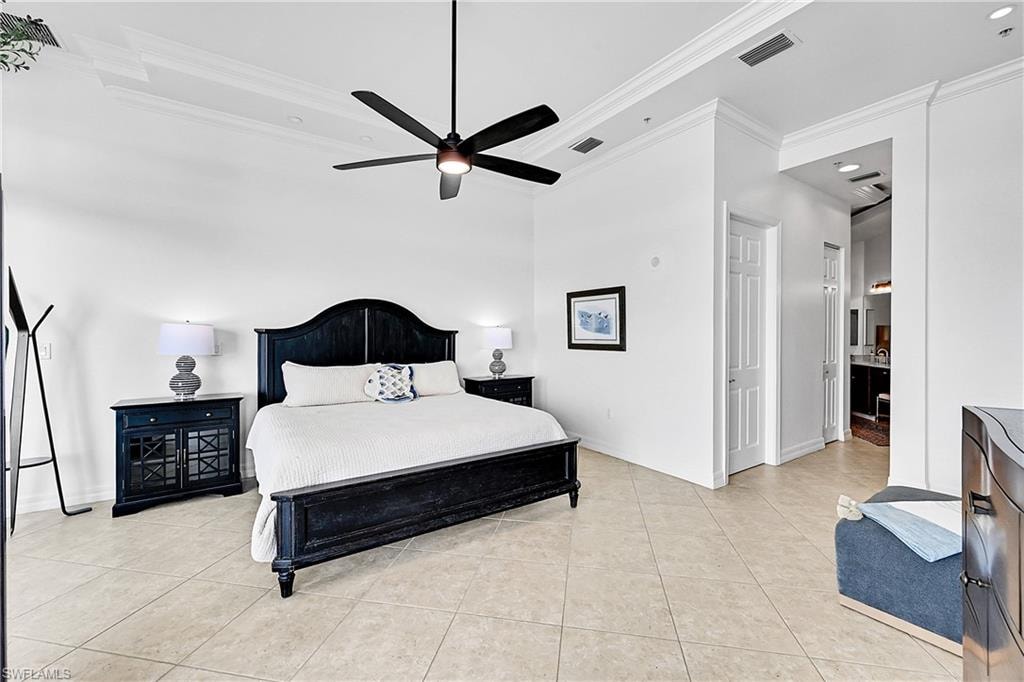 Bedroom featuring ornamental molding, light tile patterned floors, baseboards, and ensuite bathroom