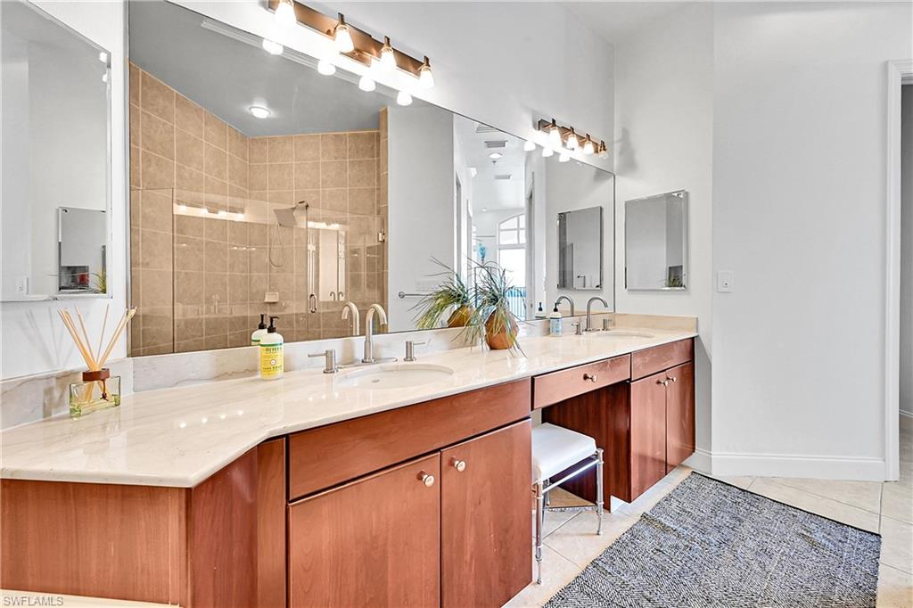 Bathroom featuring a shower stall, tile patterned flooring, and double vanity