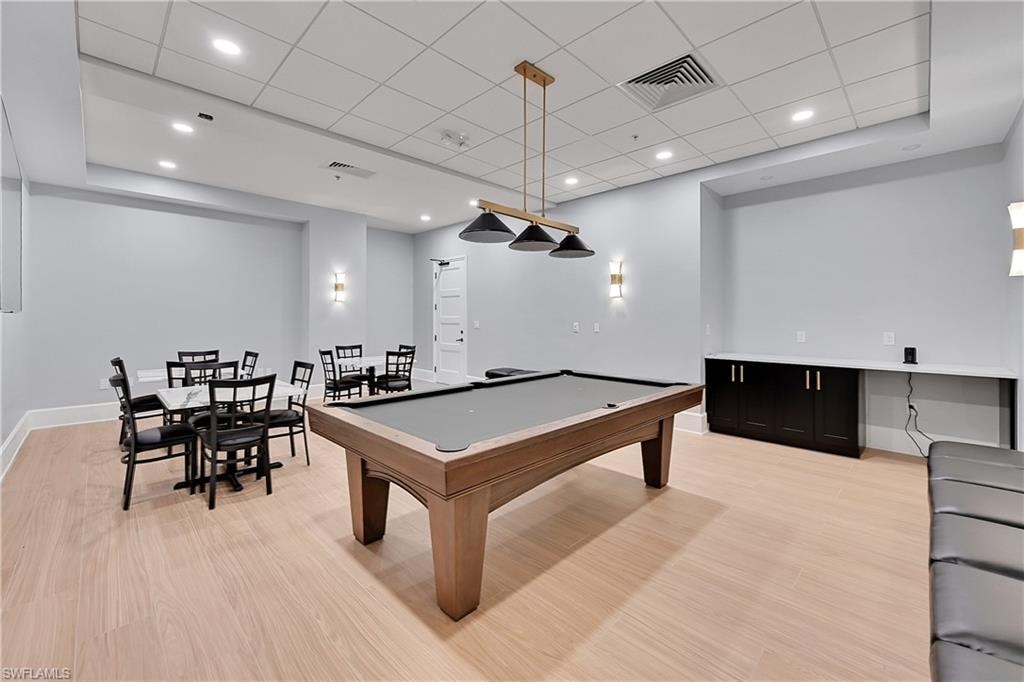Rec room with light wood-style flooring, pool table, baseboards, and a drop ceiling