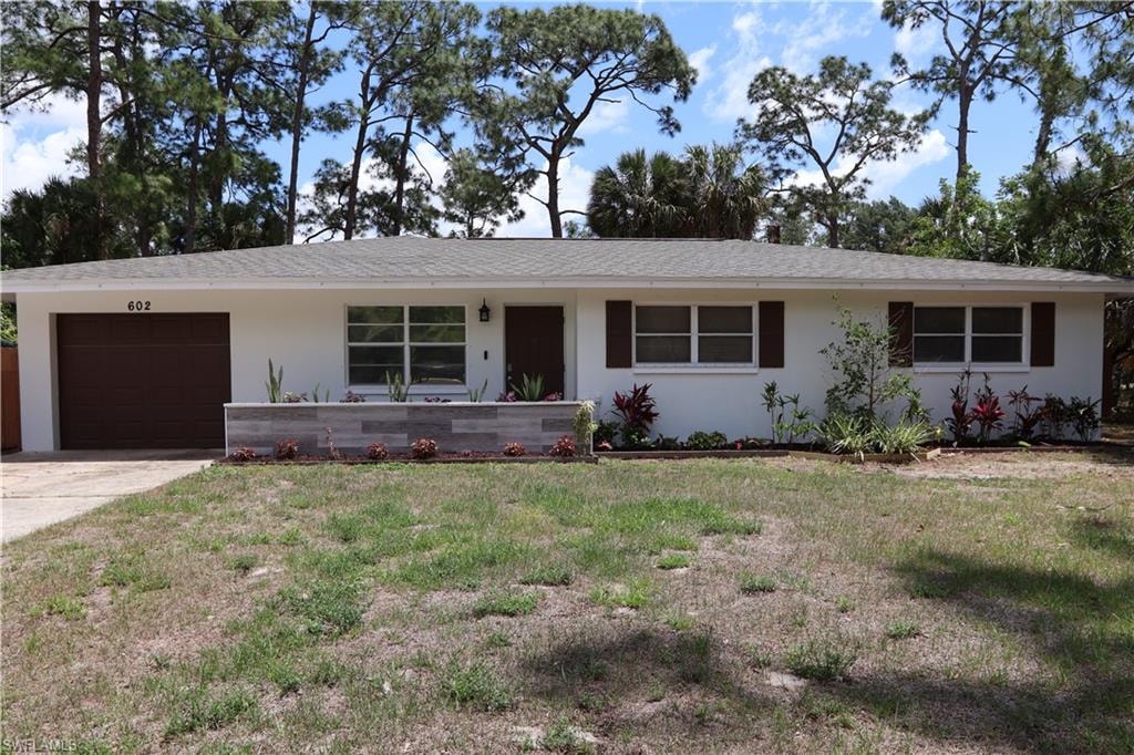 White exterior featuring a dark brown garage door, coordinating dark brown entry door, and dark brown window shutters
