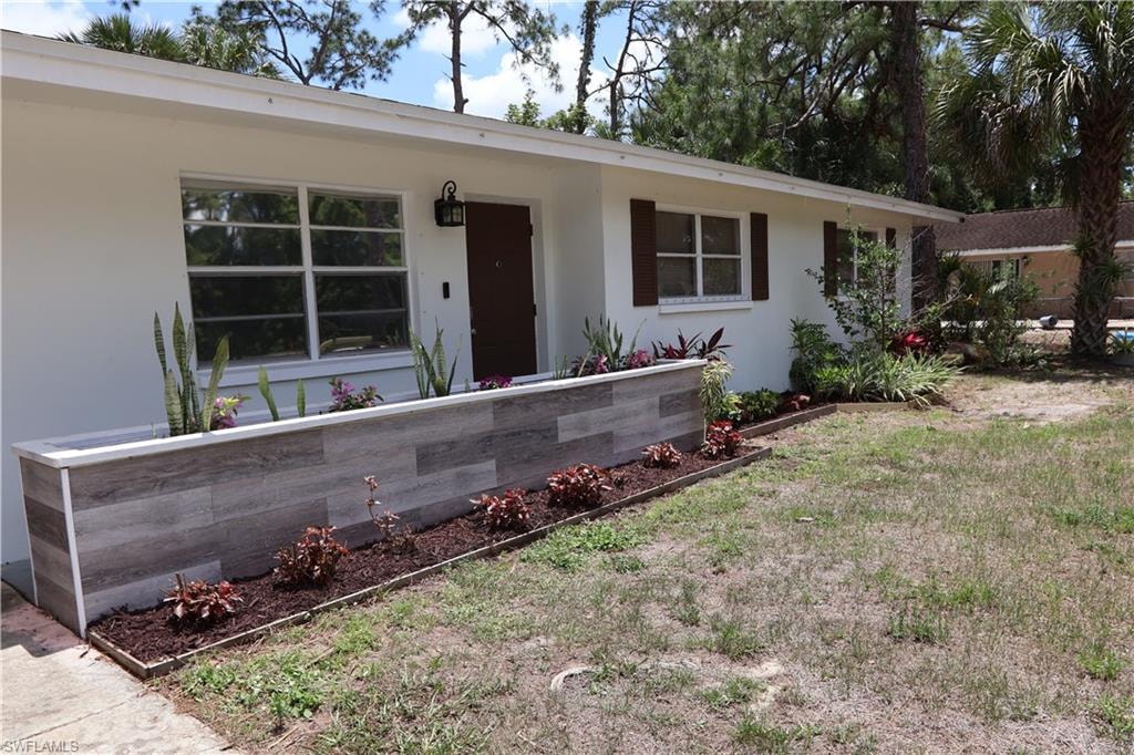 Crisp white exterior with contrasting brown window shutters and a matching front door