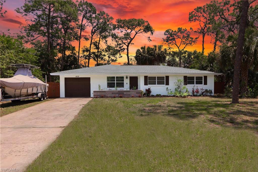 Single-story residence featuring a white exterior, a dark brown garage door, and a light-colored shingle roof