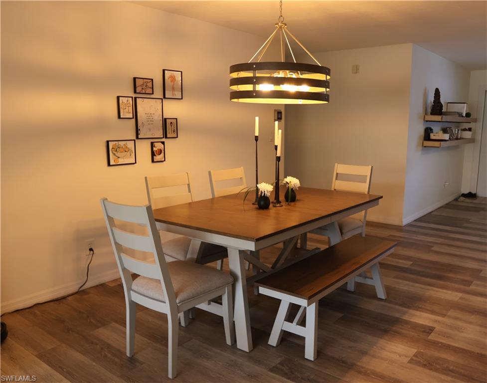 Dining area featuring wood-finish flooring and a contemporary chandelier