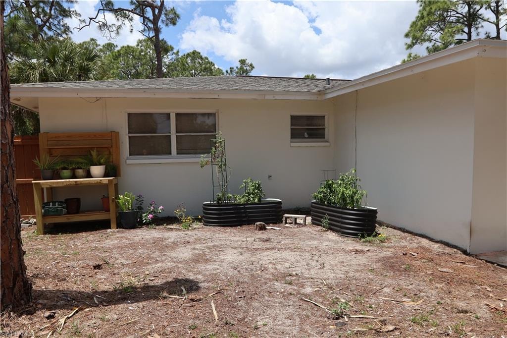 two corrugated metal raised garden beds, and a wood-finish potting bench
