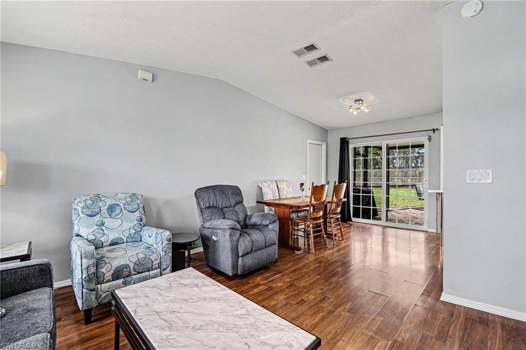 Open-concept living and dining area featuring wood-finish flooring