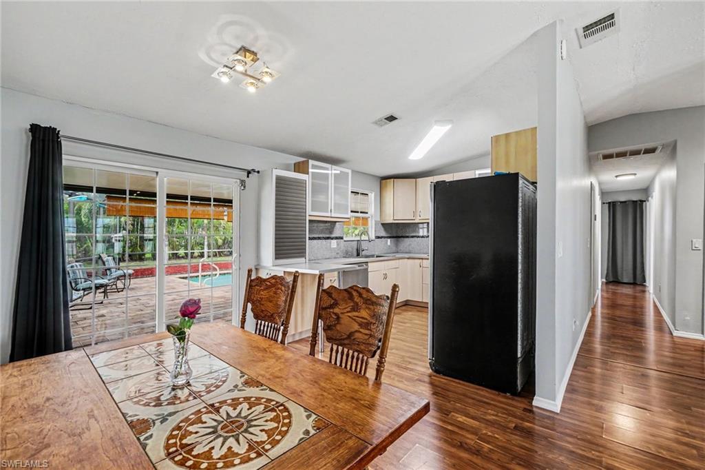 Dining area with wood-finish flooring and a wood dining table featuring a decorative tile inlay