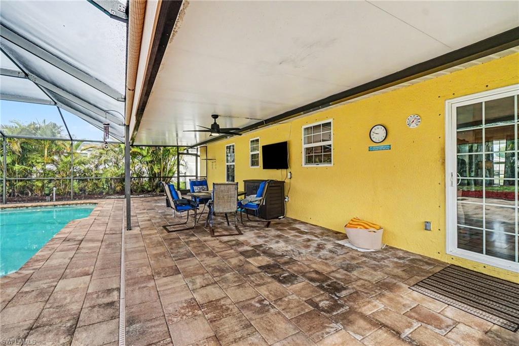 Covered patio with a paver-stone surface, screened enclosure, and ceiling fan
