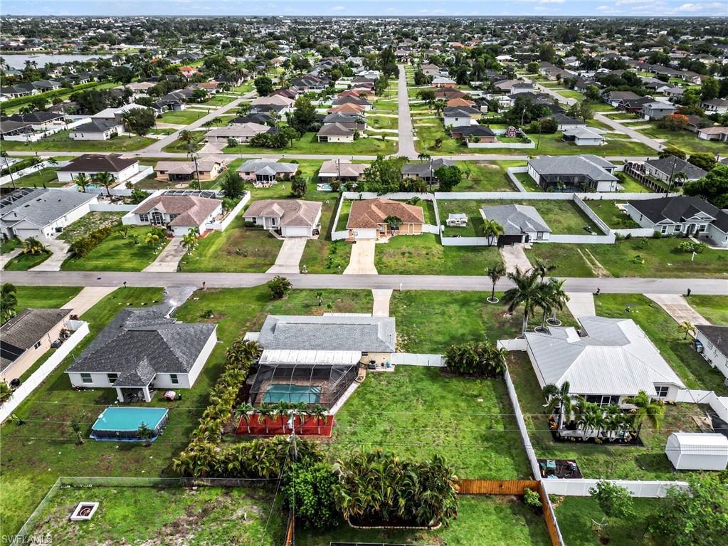 Aerial perspective of a residential neighborhood featuring single-story homes with shingle roofs and concrete driveways
