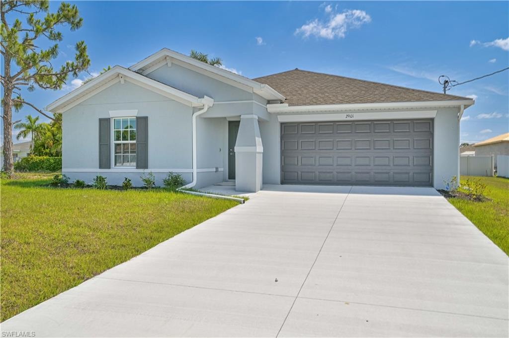 Ranch-style house featuring a front yard and a garage