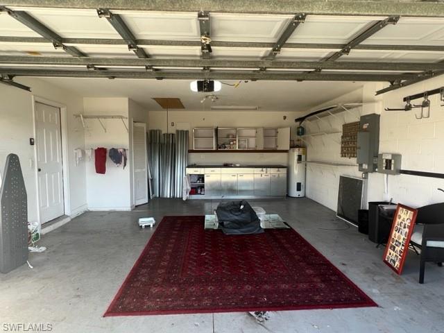 Garage featuring a garage door opener, water heater, and electric panel