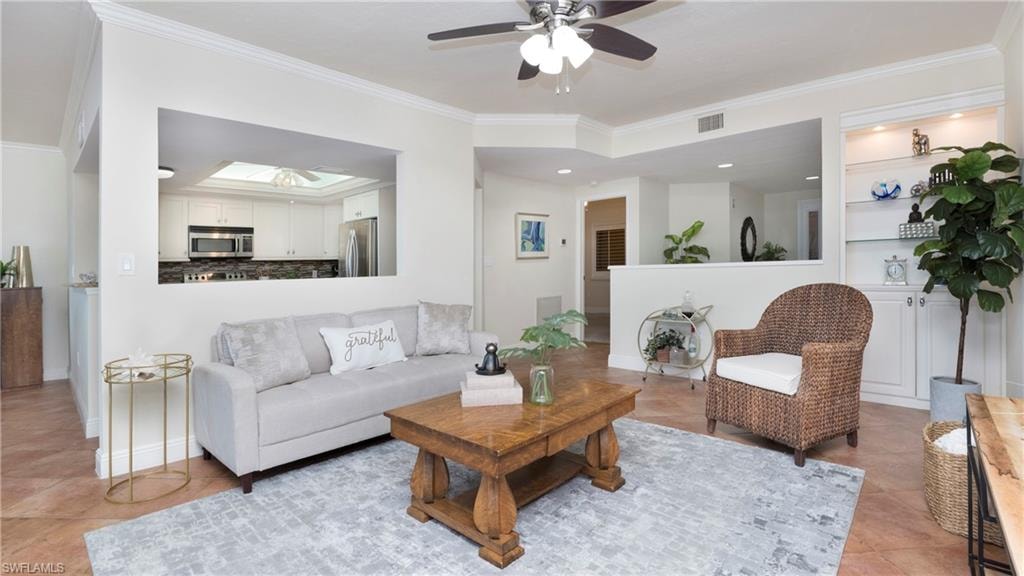 Living area featuring crown molding, light tile patterned flooring, and ceiling fan