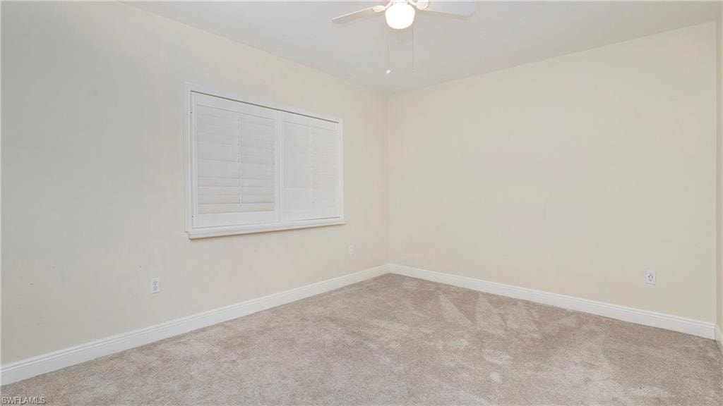 Empty room featuring carpet floors and ceiling fan