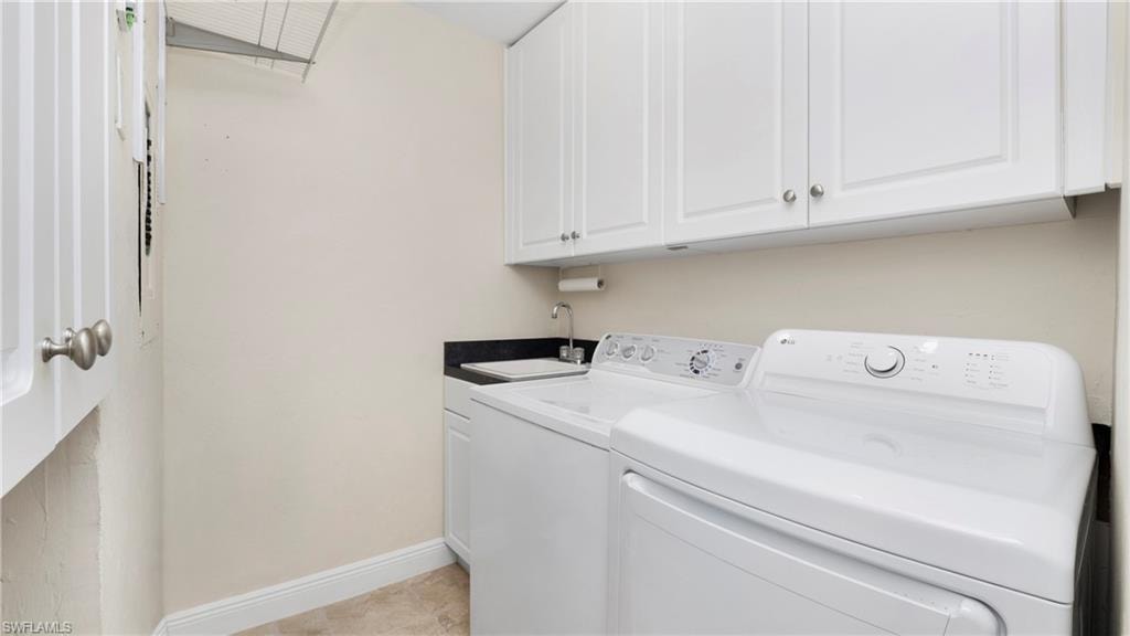 Washroom with cabinet space and washing machine and clothes dryer