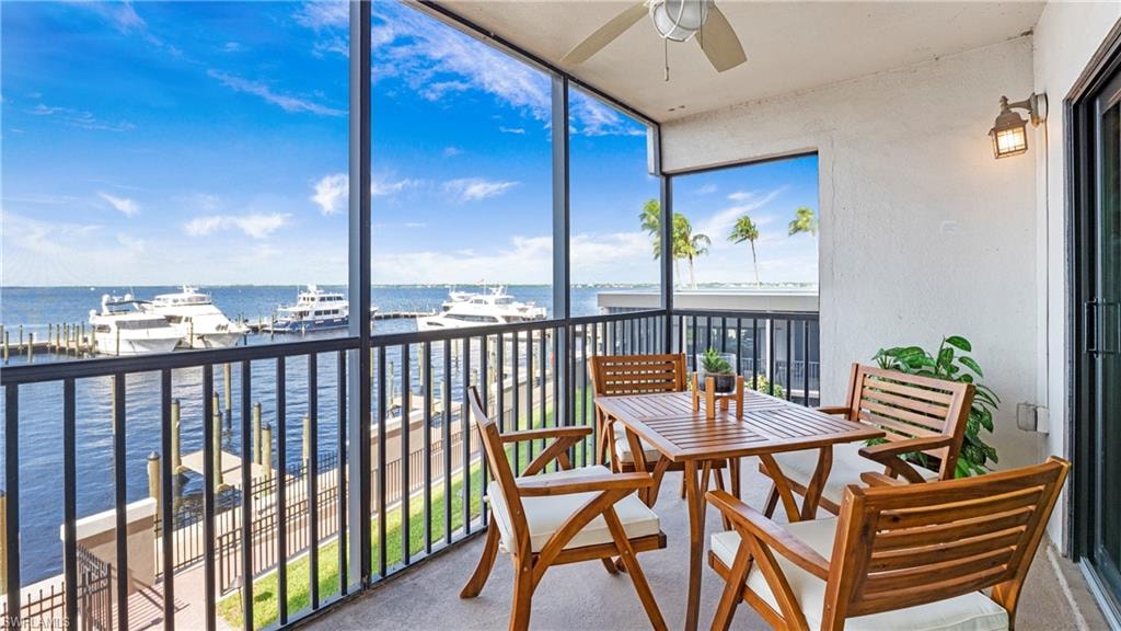 Sunroom featuring floor to ceiling windows, a water view, and carpet floors