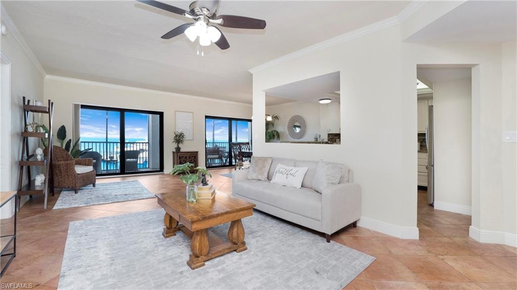 Living area with crown molding, light tile patterned flooring, and ceiling fan