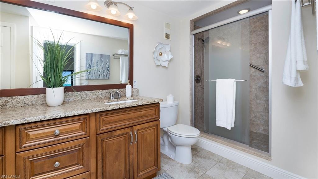Bathroom featuring vanity, a shower stall, and light tile patterned flooring